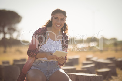 Portrait of happy woman sitting on log