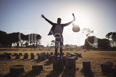 Man with arms outstretched on tree stump