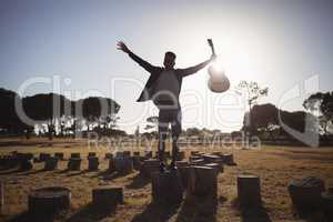 Man with arms outstretched on tree stump