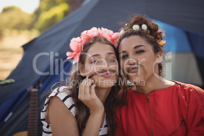 Portrait of young female friends against tent