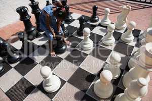 High angle view of girl playing with chess pieces