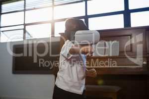 Boy wearing virtual reality simulator gesturing while standing at home