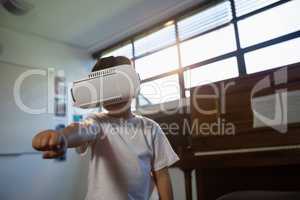 Close up of boy wearing virtual reality simulator gesturing while standing against piano