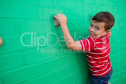 Portrait of smiling boy climbing wall at playground