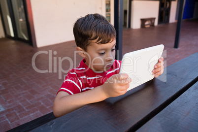 Close up of cute boy using digital laptop while sitting at table
