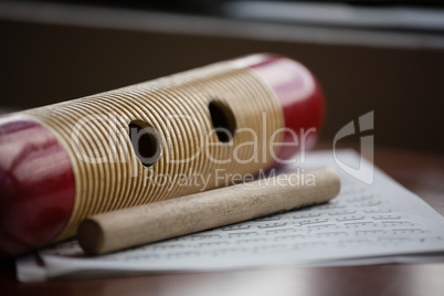 Close up of musical instrument with sheet music on wooden table