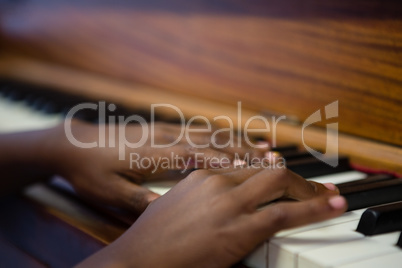 Close up of boy playing piano in classroom