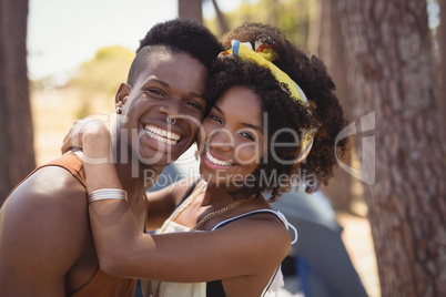 Portrait of smiling young couple standing by trees