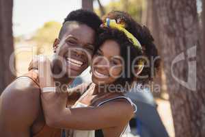 Portrait of smiling young couple standing by trees