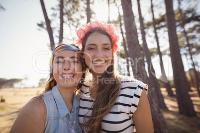 Portrait of cheerful friends standing on field