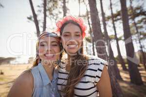 Portrait of cheerful friends standing on field