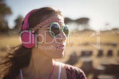 Young woman listening music while wearing sunglasses