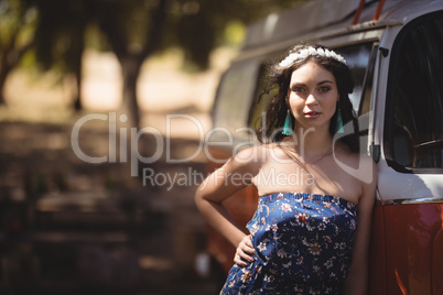 Portrait of young woman standing by motor home