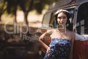 Portrait of young woman standing by motor home