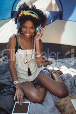 Portrait of young woman listening music on digital tablet