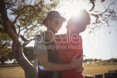 Happy young couple embracing on field