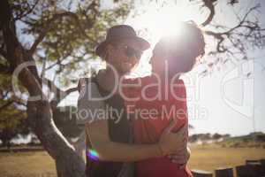 Happy young couple embracing on field