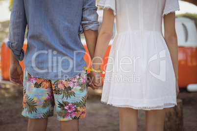 Midsection of couple standing against van