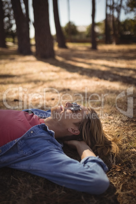 High angle view of young man relaxing on grassy field