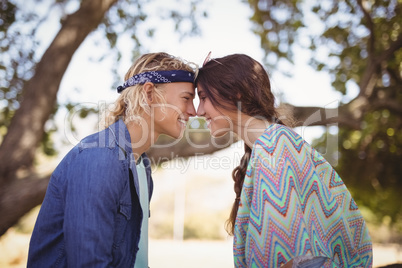Side view of romantic couple sitting on tree trunk
