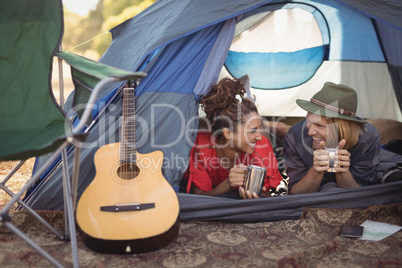 Couple talking while relaxing in tent