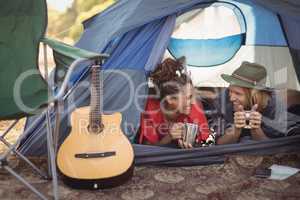 Couple talking while relaxing in tent