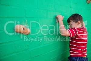 Rear view of boy climbing wall at playground