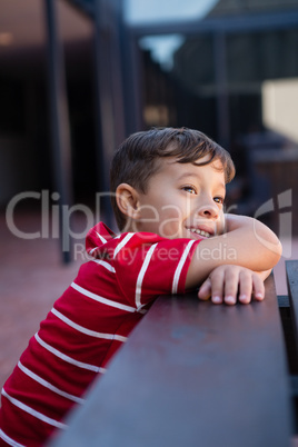 Close up of cute boy looking away while leaning on table