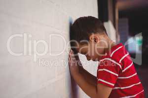 Side view of boy leaning on wall