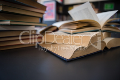 Close up of books on table against shelf in library