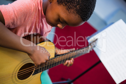 High angle view of boy playing guitar