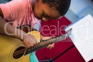 High angle view of boy playing guitar