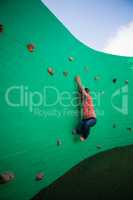 Full length of boy climbing on green wall