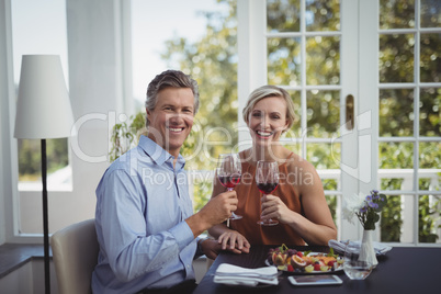 Couple toasting glasses of wine in restaurant