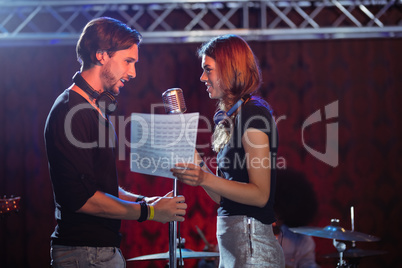 Male and female singers performing face to face