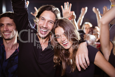 Portrait of cheerful young friends enjoying at nightclub