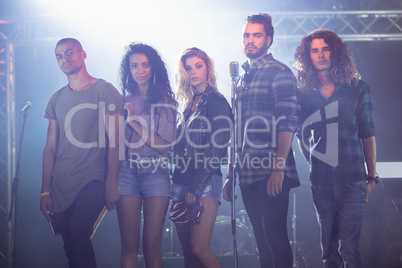 Portrait of musicians standing on stage at nightclub