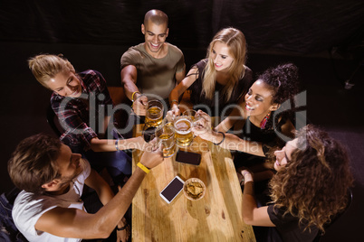 High angle view of happy friends toasting at table