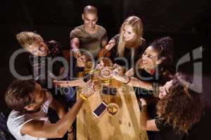 High angle view of happy friends toasting at table