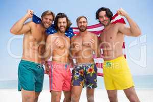 Portrait of playful male friends holding American flag