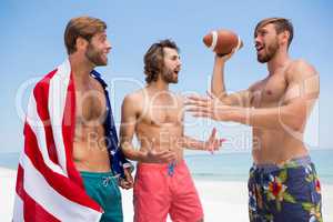 Shirtless male friends talking while standing against clear sky