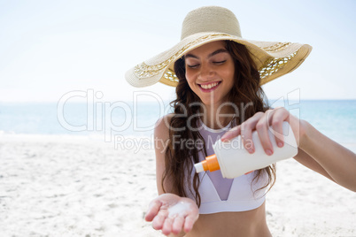 Smiling woman pouring cream on palm