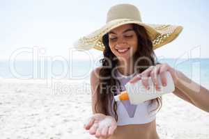 Smiling woman pouring cream on palm