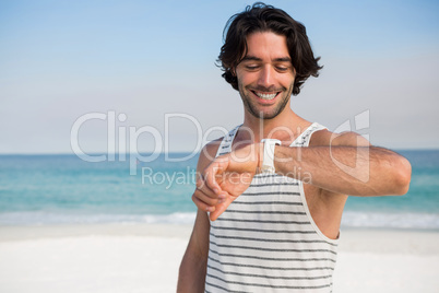 Smiling man looking at wristwatch