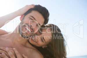 Smiling couple embracing at beach