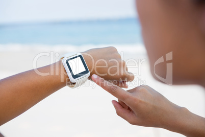 Cropped woman using smart watch at beach