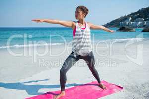 Full length of young woman exercising at beach