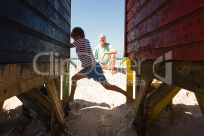 Happy boy playing with grandfather by huts