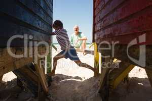 Happy boy playing with grandfather by huts