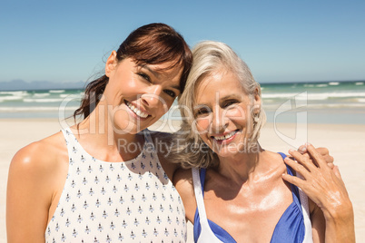 Portrait of smiling mother and daughter standing against clear sky